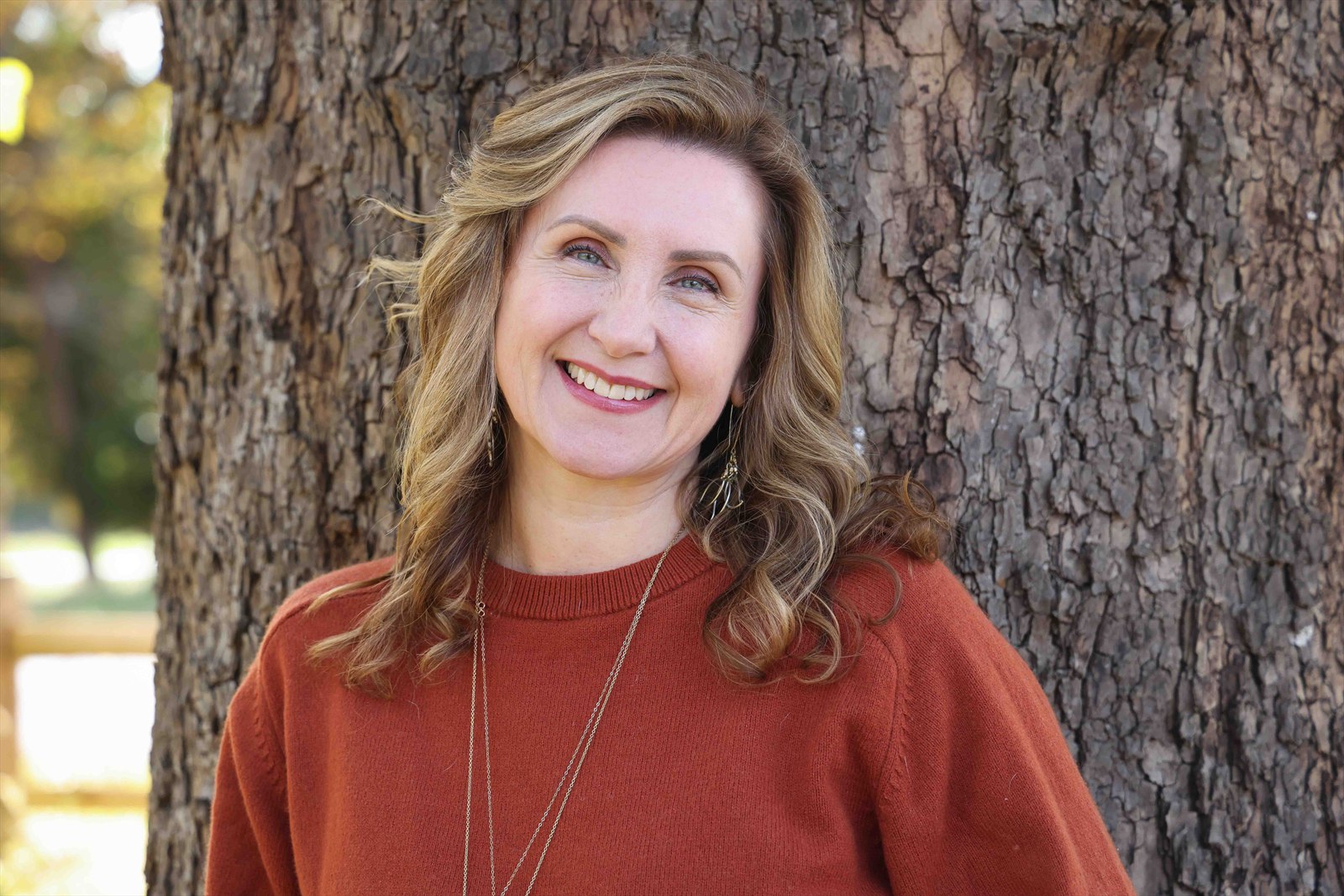 Christine Dorsey smiling beside a tree